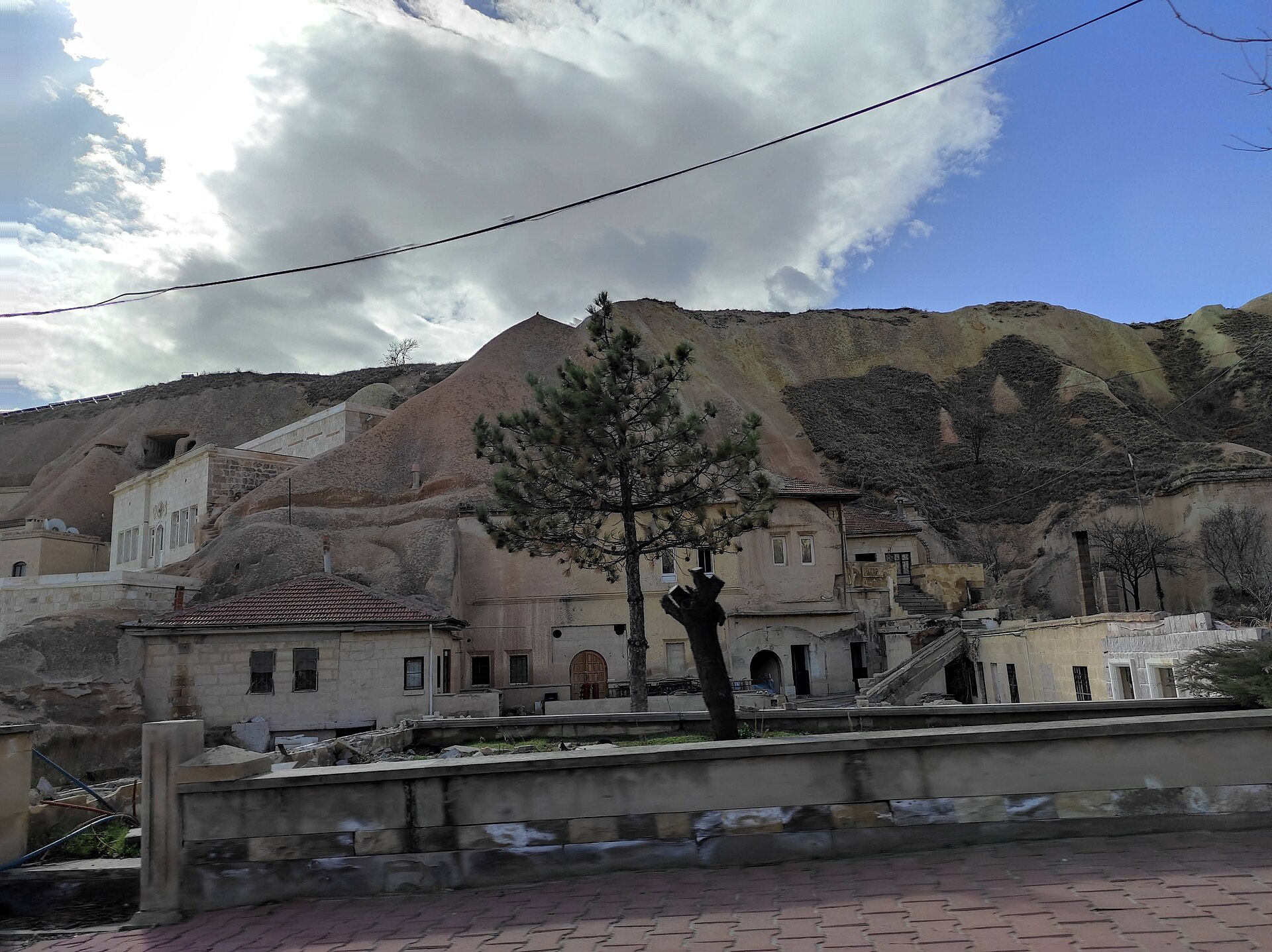 Stone houses and cave dwellings cut into the hillside of a Cappadocian village